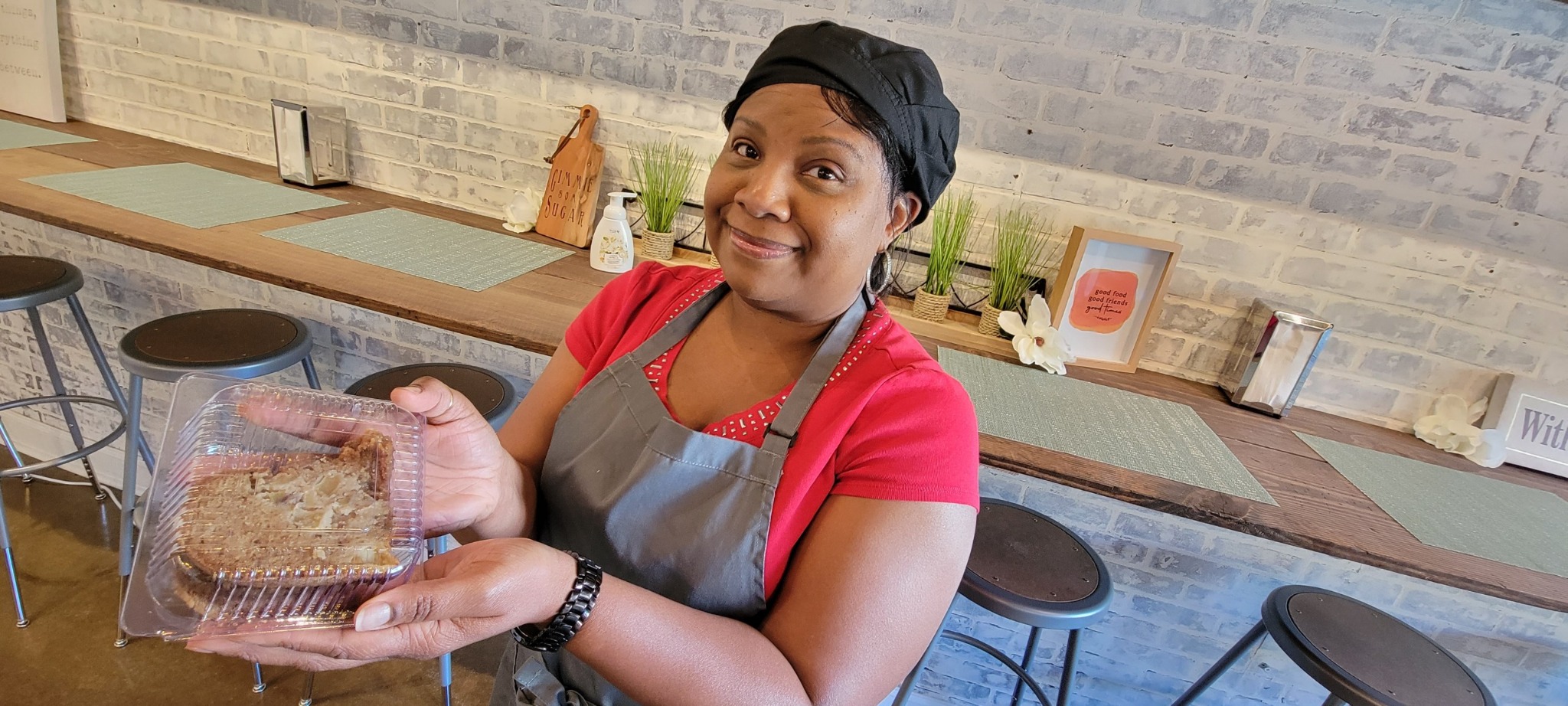 Mrs. Moore smiling while presenting a fresh bakery treat